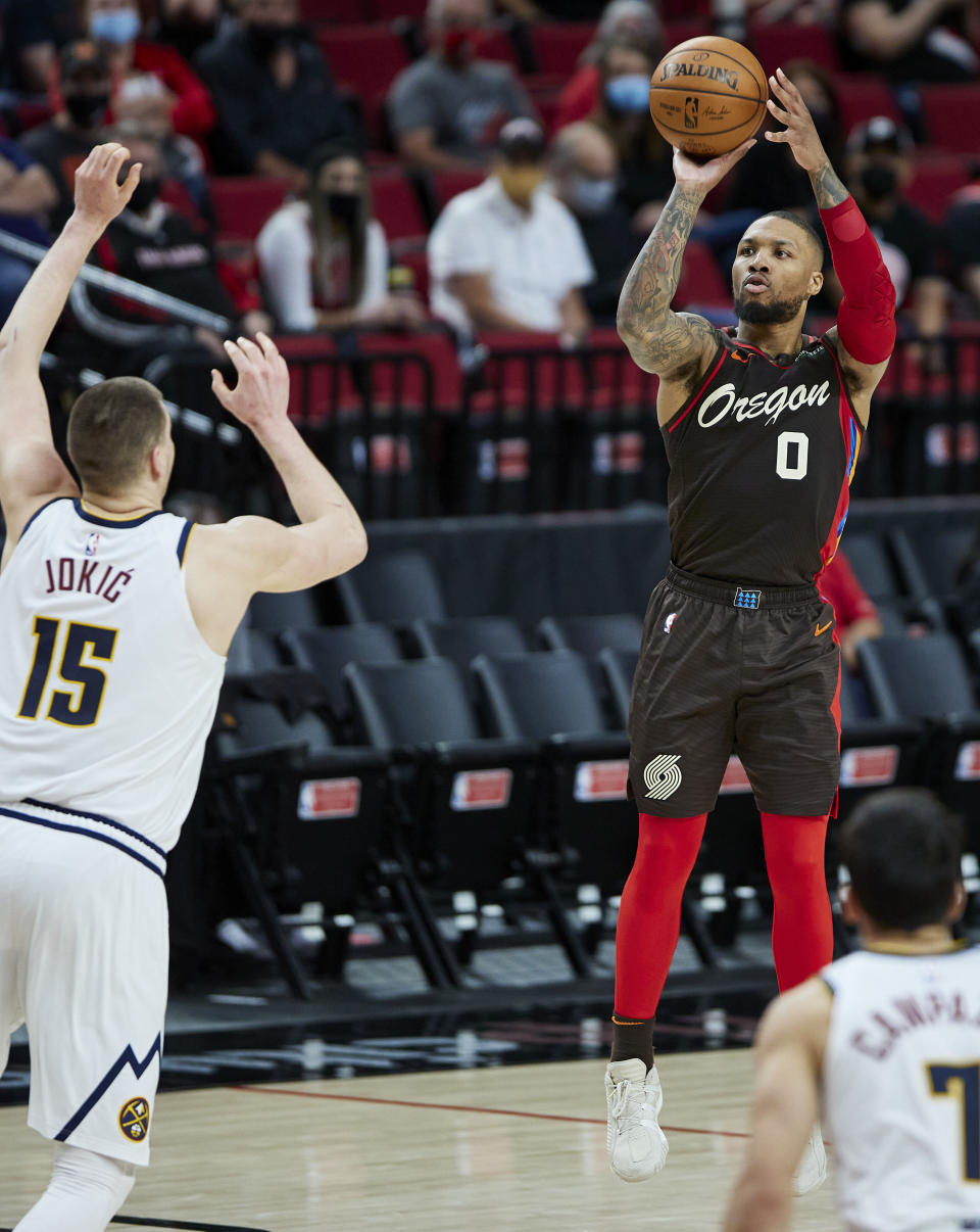 Portland Trail Blazers guard Damian Lillard shoots a 3-pointer Denver Nuggets center Nikola Jokic during the second half of Game 6 of an NBA basketball first-round playoff series Thursday, June 3, 2021, in Portland, Ore. (AP Photo/Craig Mitchelldyer)