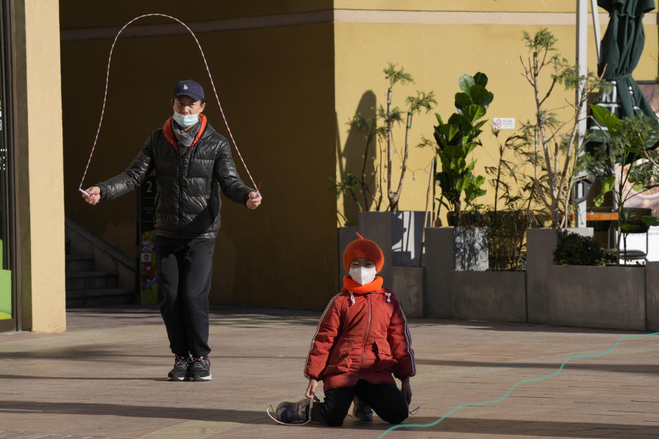 Visitors to a shopping mall jump ropes as they enjoy the mild weather in Beijing, Tuesday, Dec. 27, 2022. Companies welcomed China's decision to end quarantines for travelers from abroad as an important step to revive slumping business activity while Japan on Tuesday announced restrictions on visitors from the country as infections surge. (AP Photo/Ng Han Guan)