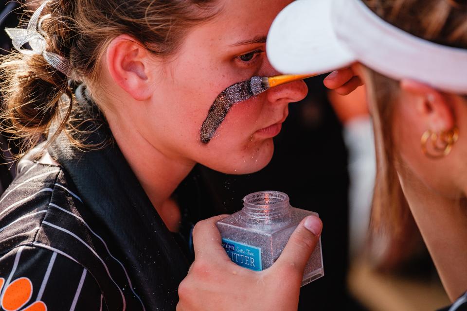Strasburg pitcher, Amelia Spidell, gets a coating of glitter applied to her face shortly before the OHSAA DIV State Softball Semifinal game against Gibsonburg, Friday, June 2 at Firestone Stadium in Akron.
