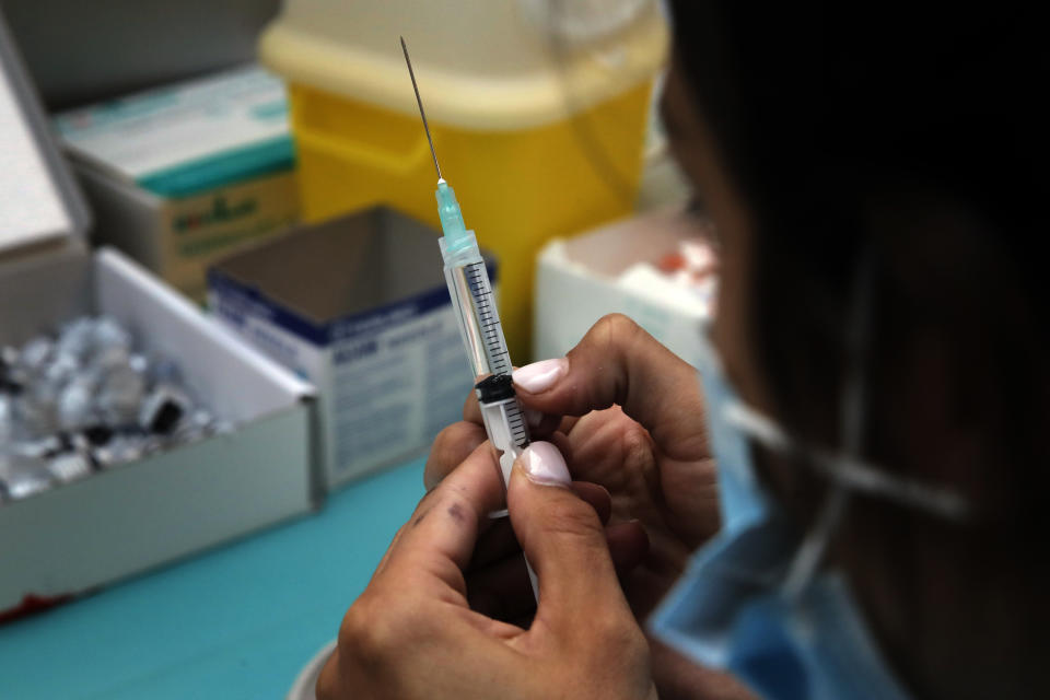 A medical staff prepares Pfizer's COVID-19 vaccine at a vaccination site in Paris, Saturday, March 6, 2021. The government plans to inoculate 10 million citizens by mid-April, 20 million by mid-May and a total of 30 million, or two-thirds of the adults by summer. (AP Photo/Christophe Ena)