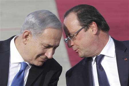 French President Francois Hollande listens to Israel's Prime Minister Benjamin Netanyahu (L) during his welcome ceremony at Jerusalem's Ben Gourion airport for a tree-days state visit, November 17, 2013. Israeli Prime Minister Benjamin Netanyahu pressed France on Friday not to weaken in its stance toward Iran in upcoming talks on the Islamic state's nuclear programme REUTERS/Philippe Wojazer