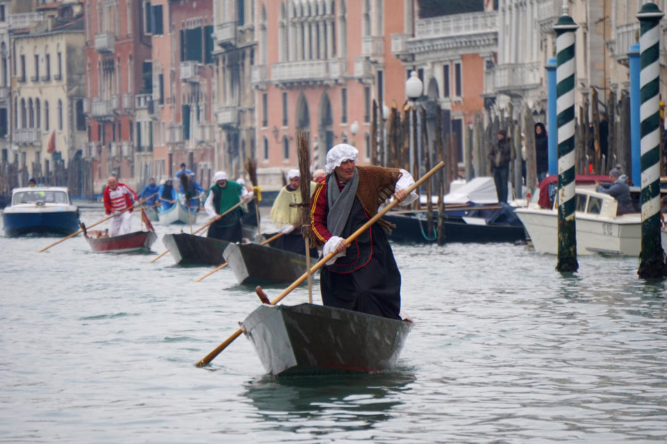 Gondoliers disguised as old women row on the Grand Canal in Venice, Italy, during the traditional Epiphany regatta Monday, Jan. 6, 2020 . (Anteo Marinoni/LaPresse via AP)