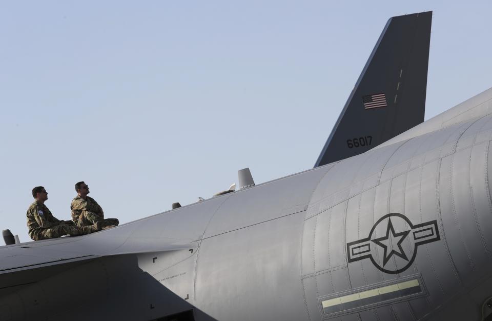 American pilots watch a flying display sitting on top of an aircraft during the opening day of Dubai Airshow in Dubai, United Arab Emirates, Sunday, Nov. 17, 2019. (AP Photo/Kamran Jebreili)