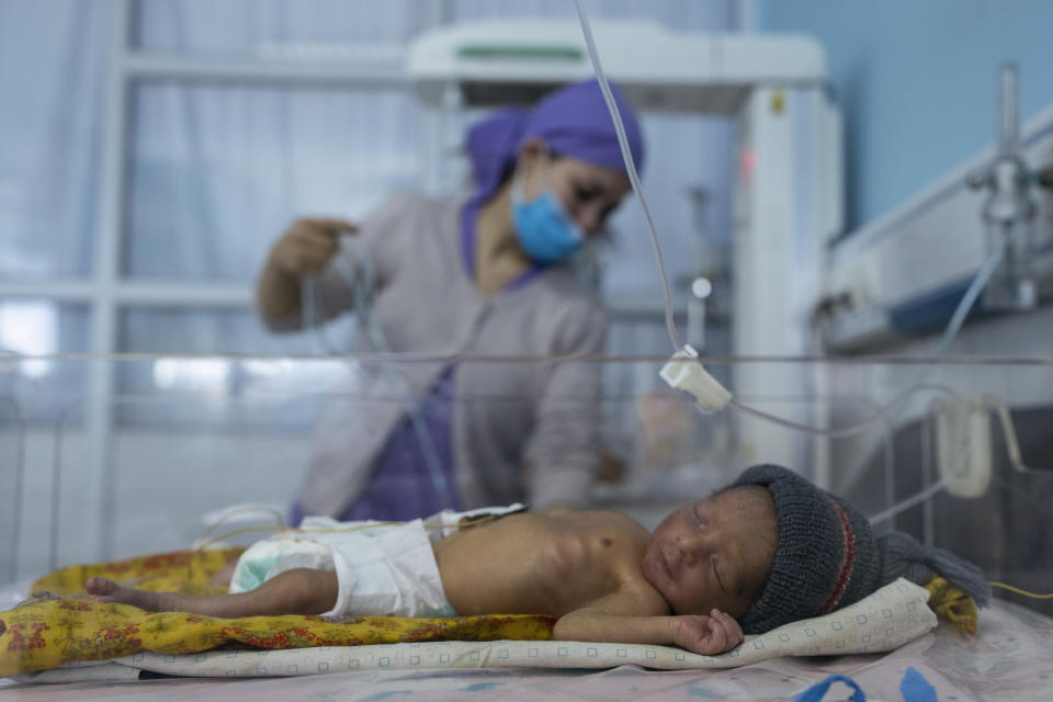 FILE - A nurse takes care of a baby in the neonatal intensive care unit of Malalai Maternity hospital in Kabul Afghanistan, on Dec. 9, 2021. As winter deepens, a grim situation in Afghanistan is getting worse. Freezing temperatures are compounding the misery from the downward spiral that has come with the fall of the U.S.-backed government and the Taliban takeover. Aid groups and international agencies estimate about 23 million people, half the country, face severe hunger and nearly 9 million are on the brink of starvation.(AP Photo/ Petros Giannakouris, File)