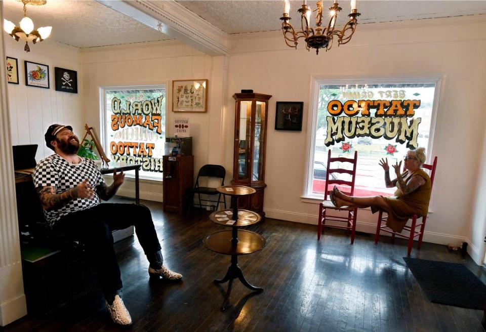 Tattoo artist Davey Gant, left, and Mickey Haake, who works the front desk, share a laugh on a recent afternoon at the Bert Grimm Tattoo Museum. 