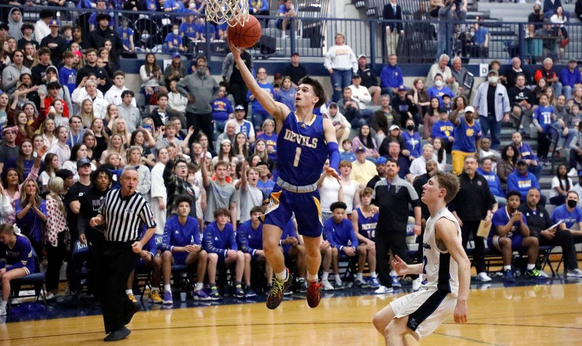 Henry Clay’s Konlin Brown (1) drives past Lexington Catholic’s John Reinhart (22) during the 11th region quarterfinal basketball game at Lexington Catholic High School in Lexington, Ky., Tuesday, March 1, 2022.