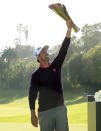 Adam Scott, of Australia, hoists his trophy on the 18th green after winning the Genesis Invitational golf tournament at Riviera Country Club, Sunday, Feb. 16, 2020, in the Pacific Palisades area of Los Angeles. (AP Photo/Ryan Kang)