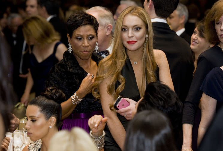 Lindsay Lohan, with her attorney Shawn Chapman Holley, arriving at her table, where Kim Kardashian was parked, in 2012. (Photo: Kristoffer Tripplaar-Pool/Getty Images)