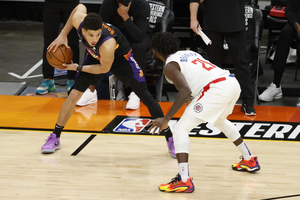 Devin Booker of the Phoenix Suns controls the ball ahead of Patrick Beverley of the LA Clippers