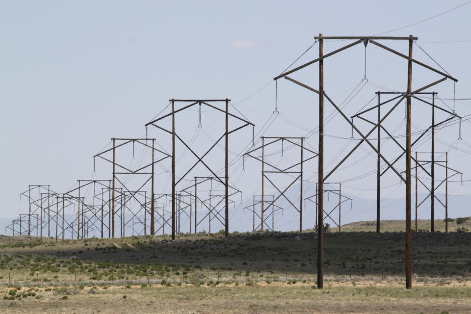 FILE - This May 20, 2012 file photo shows one of the major transmission lines that runs to the west of Albuquerque, N.MThe federal government has finished another environmental review of a proposed transmission line that will carry wind-generated electricity from rural New Mexico to big cities in the West and similar reviews are planned for two more projects that would span parts of Utah and Nevada, the U.S. Interior Department announced Thursday, April 28, 2022. (AP Photo/Susan Montoya Bryan, File)