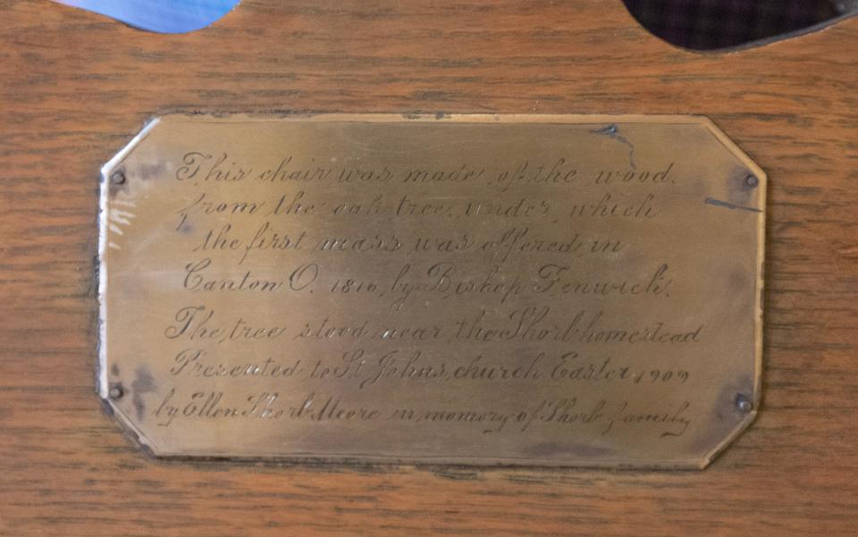 A plaque shares the story of the history of the Basilica of Saint John the Baptist in Canton. The first Mass was held under an oak tree and the chair is made from the wood of that tree.