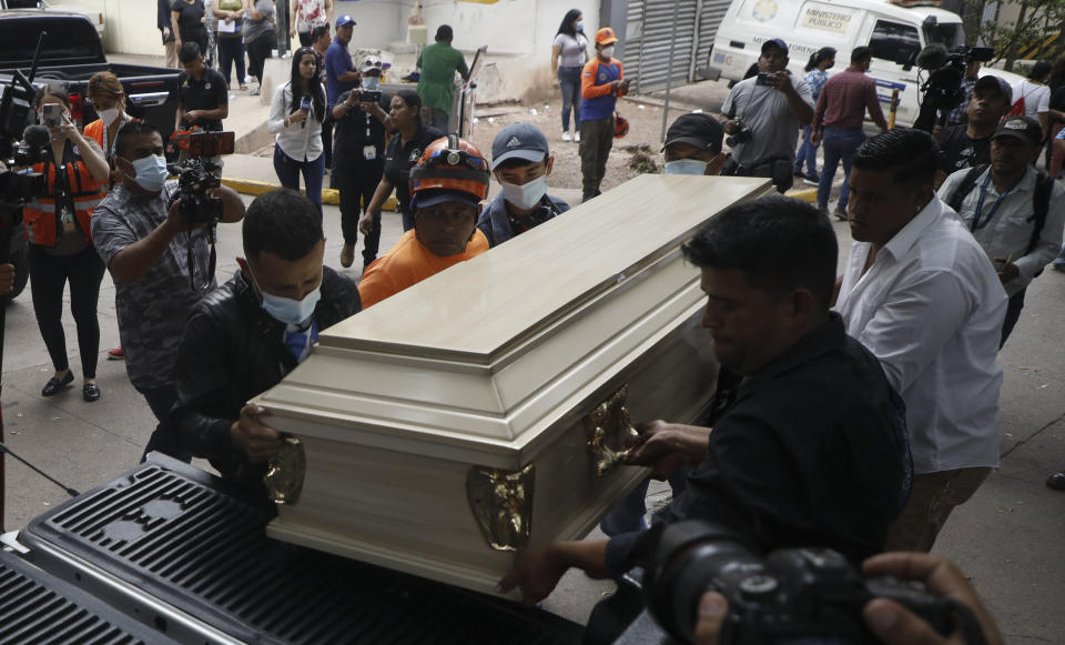 Varias personas colocan un ataúd que contiene los restos de una presa en un auto fúnebre en Tegucigalpa, Honduras, el miércoles 21 de junio de 2023. Al menos 46 internas murieron en un mo´tin en una prisión para mujeres en la capital de Honduras. (AP Foto/Elmer Martinez)