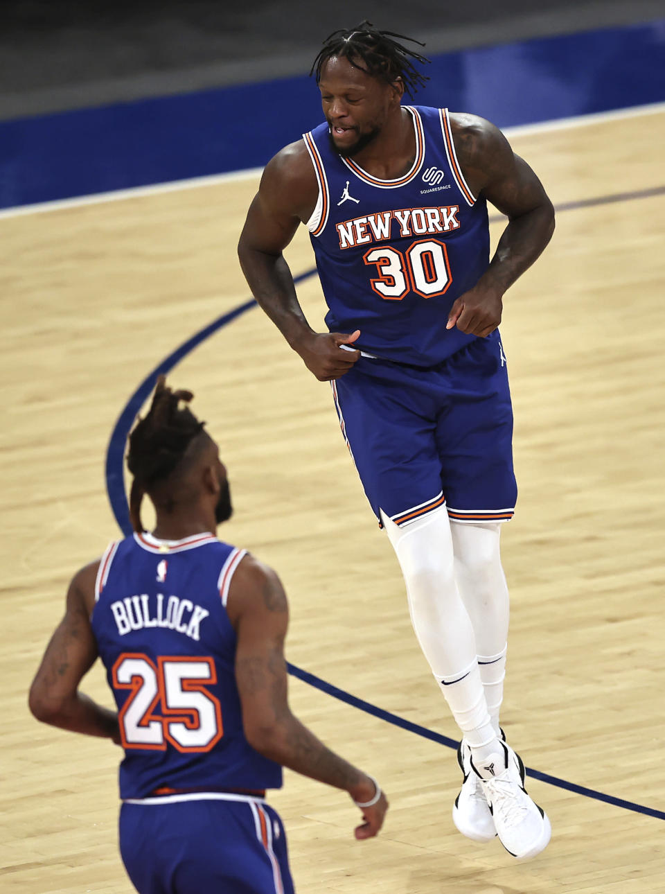 New York Knicks' Julius Randle (30) celebrates his three-point basket with teammate Reggie Bullock (25) in the third quarter of an NBA basketball game against the Phoenix Suns, Monday, April 26, 2021, in New York. (Elsa/Pool Photo via AP)
