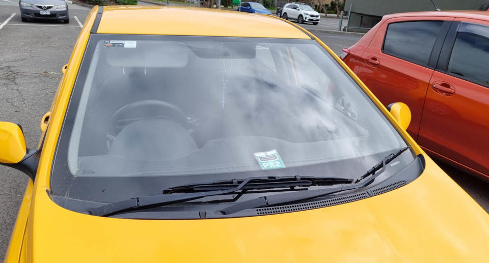 A photo of the yellow car with a double time permit showing behind the windscreen at at the Woolies Bayswater carpark in Melbourne.