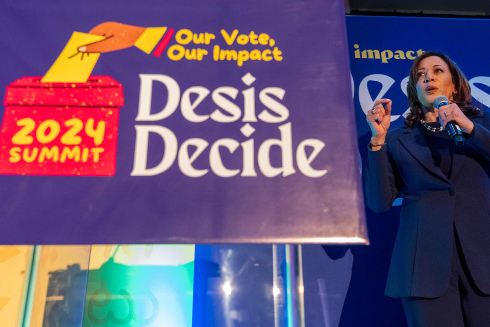 Kamala Harris speaks  next to a sign that reads 