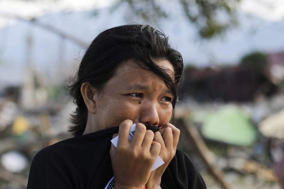 In this Oct. 5, 2018, file photo, Musrifah breaks into tears as she visits the area where her house used to stand before a massive earthquake and tsunami hit their seaside village in Palu, Central Sulawesi, Indonesia. (AP Photo/Aaron Favila)