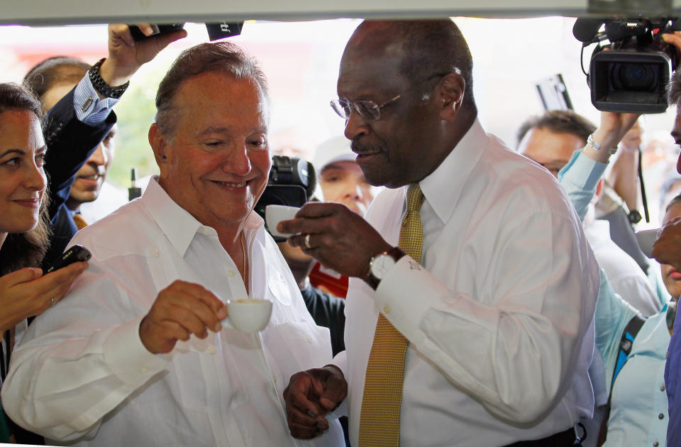 Republican Presidential candidate Herman Cain drinks a Cuban coffee with Felipe Valls, Sr., during a campaign visit to Versailles in 2011. (Joe Raedle / Getty Images file)