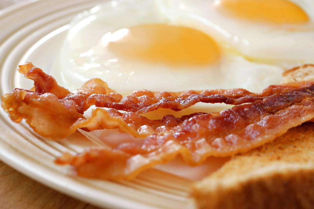 breakfast of crispy bacon, fried eggs and toast