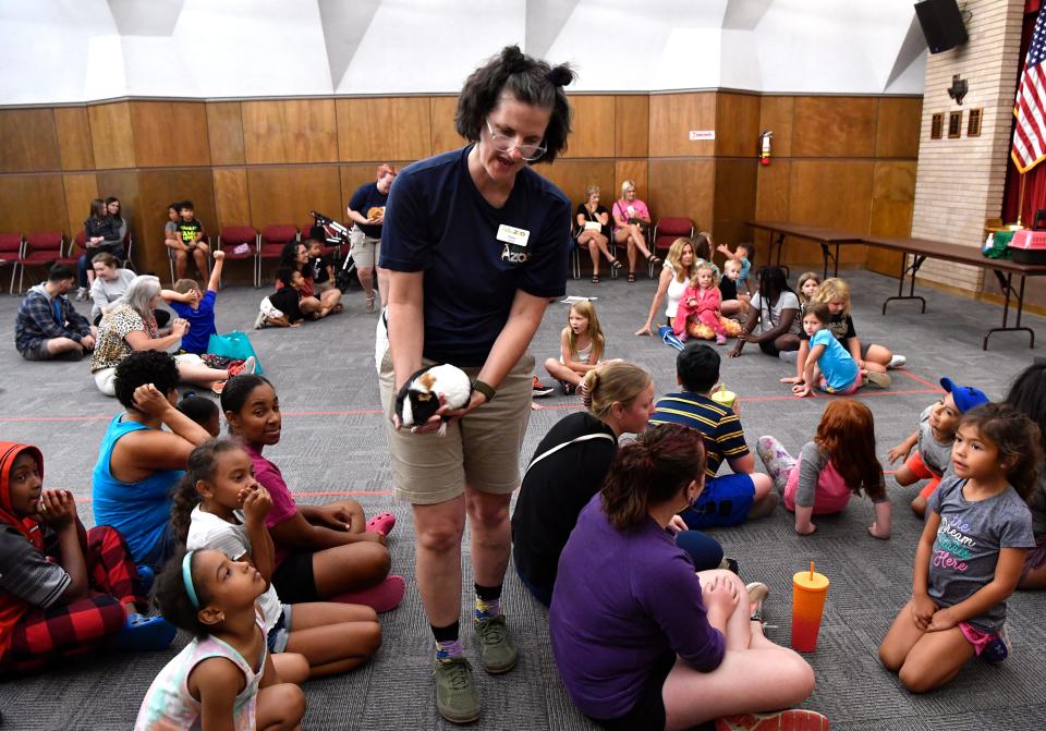 Hilary Blackketter, an educator at the Abilene Zoo, shows a guinea pig to children during Thursday’s Animal Ambassadors program at the Abilene Public Library’s Main Branch July 6, 2023.