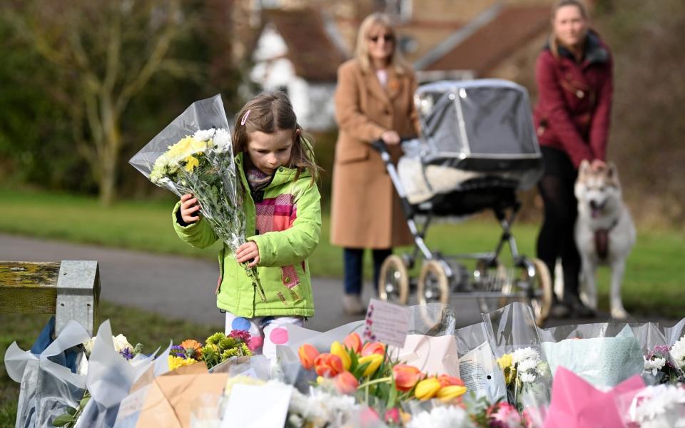 Noelle Simmons, aged 4, lays flowers near the former home of Captain Sir Tom Moore -  Leon Neal/Getty Images Europe