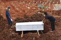 Workers prepare a coffin for burial at the special section of Jombang cemetery which was opened to accommodate the surge in deaths during coronavirus outbreak, in Tangerang, Indonesia, Tuesday, Jan. 26, 2021. Indonesia has reported more cases of the virus than any other countries in Southeast Asia. (AP Photo/Tatan Syuflana)