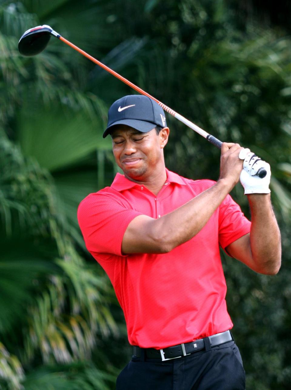 Tiger Woods grimaces after hitting from the 12th tee during the final round of the Cadillac Championship golf tournament Sunday, March 11, 2012, in Doral, Fla. Woods withdrew from the tournament, and was driven away in a cart. (AP Photo/Wilfredo Lee)