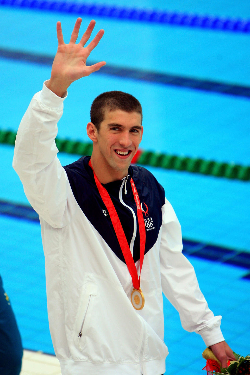 <b>Medal No. 15</b><br>Gold medalist Michael Phelps waves during the medal ceremony for the Men's 100m Butterfly in Beijing. His seventh gold of the games tied Mark Spitz for most golds in one Olympiad.