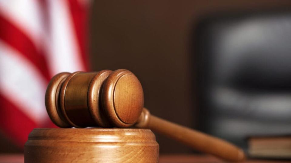 Judge Wooden gavel on the table of judge with american flag and black chair