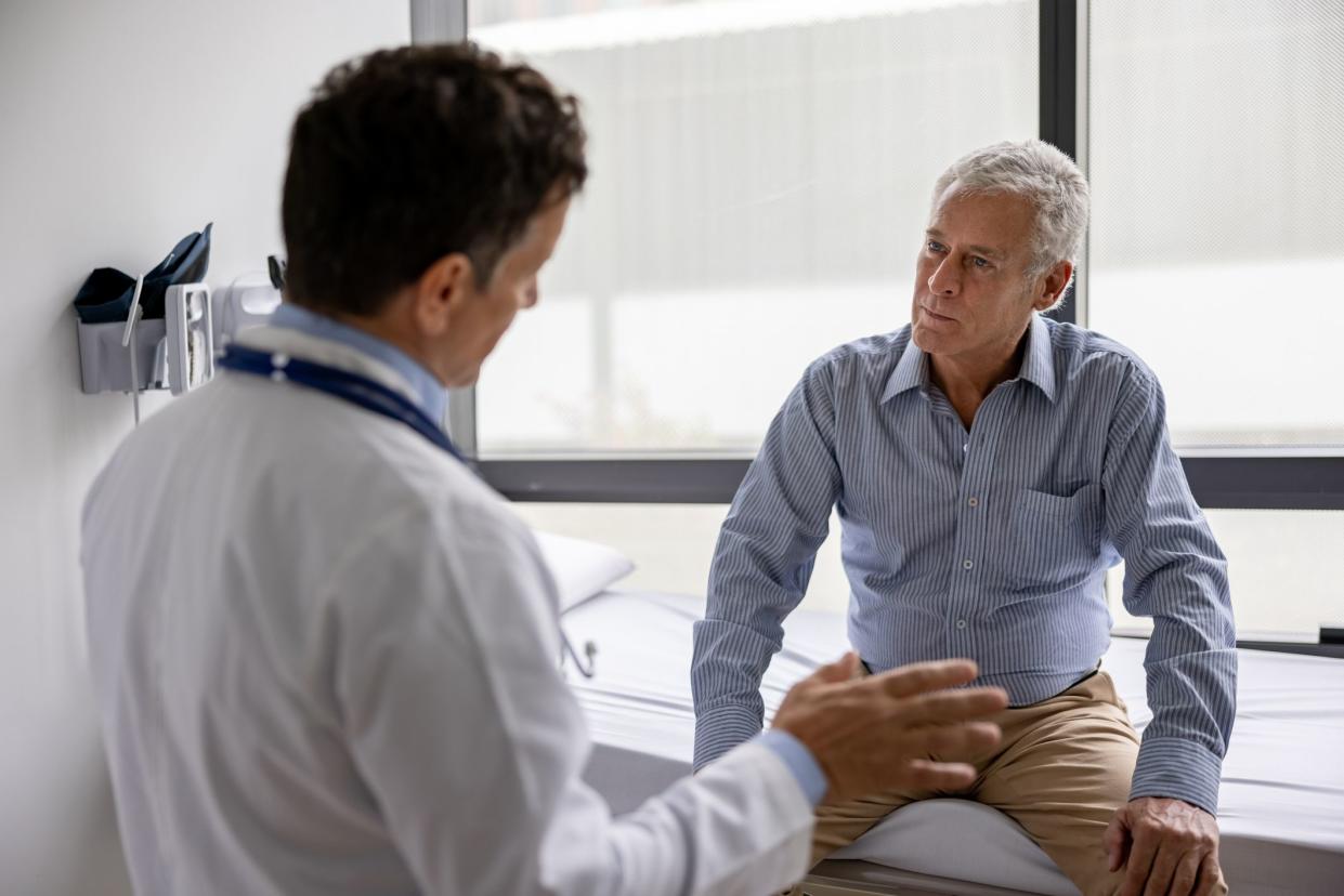 Latin American doctor talking to a patient in a consultaton at his office practice - healthcare and medicine concepts