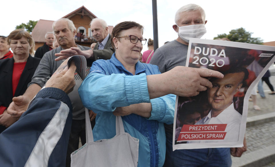 In this Tuesday, July 7, 2020 photo supporters of conservative incumbent president Andrzej Duda, who is seeking reelection in a tight presidential election runoff on Sunday, July 12, 2020 atttend a rally in Tykocin, Poland. Duda, who has backing from Poland's ruling right-wing party, is running against liberal Warsaw mayor, Rafal Trzaskowski. Opinion polls suggest the election may be decided by a small number of votes. (AP Photo/Czarek Sokolowski)