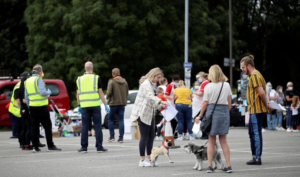 People queue near the Crown and Anchor pub following a spike in cases of the coronavirus disease (COVID-19) to visitors of the pub in Stone, Britain, July 29, 2020. REUTERS/Carl Recine