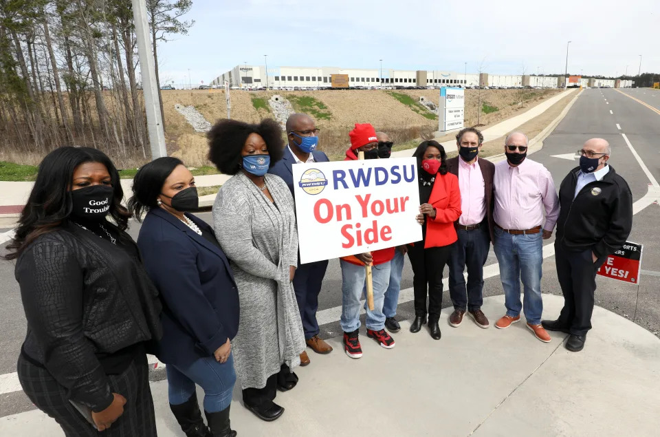 Politcians and RWDSU President Stuart Appelbaum pose for a picture at the entrance to the Amazon facility in Bessemer.