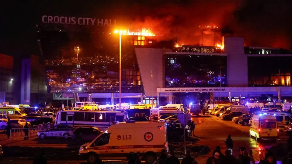 Ambulances and vehicles of Russian emergency services parked at the burning Crocus City Hall concert venue. - Yulia Morozova/Reuters