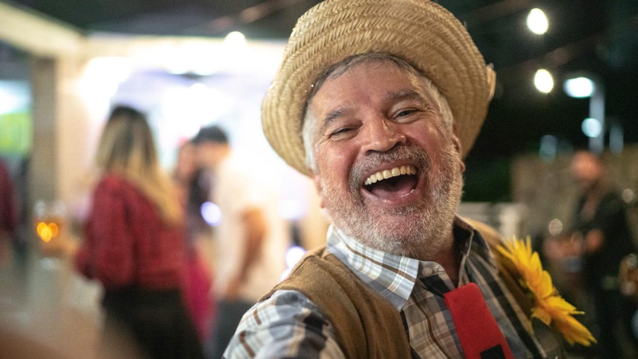 Man wearing costume for junina party, taking a selfie.