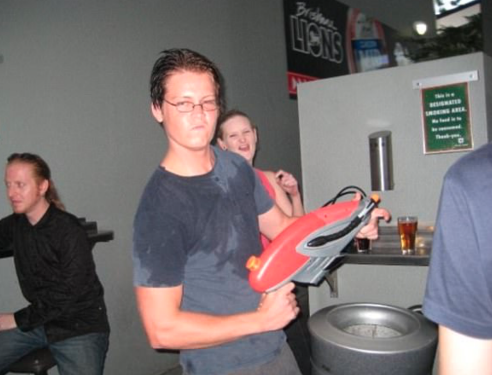 The 34-year-old traded in his blonde tips for dark hair posing with a super soaker in a bar. Source: Facebook