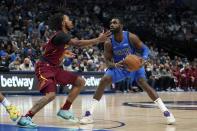 Cleveland Cavaliers guard Darius Garland, left, defends as Dallas Mavericks forward Tim Hardaway Jr., right, looks to shoot in the first half of an NBA basketball game in Dallas, Monday, Nov. 29, 2021. (AP Photo/Tony Gutierrez)