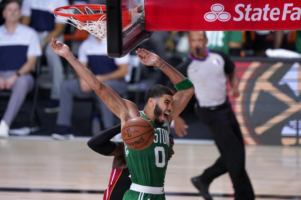 Boston Celtics' Jayson Tatum (0) celebrates dunking in front of Miami Heat's Kendrick Nunn, rear, during the second half of an NBA conference final playoff basketball game, Saturday, Sept. 19, 2020, in Lake Buena Vista, Fla. (AP Photo/Mark J. Terrill)