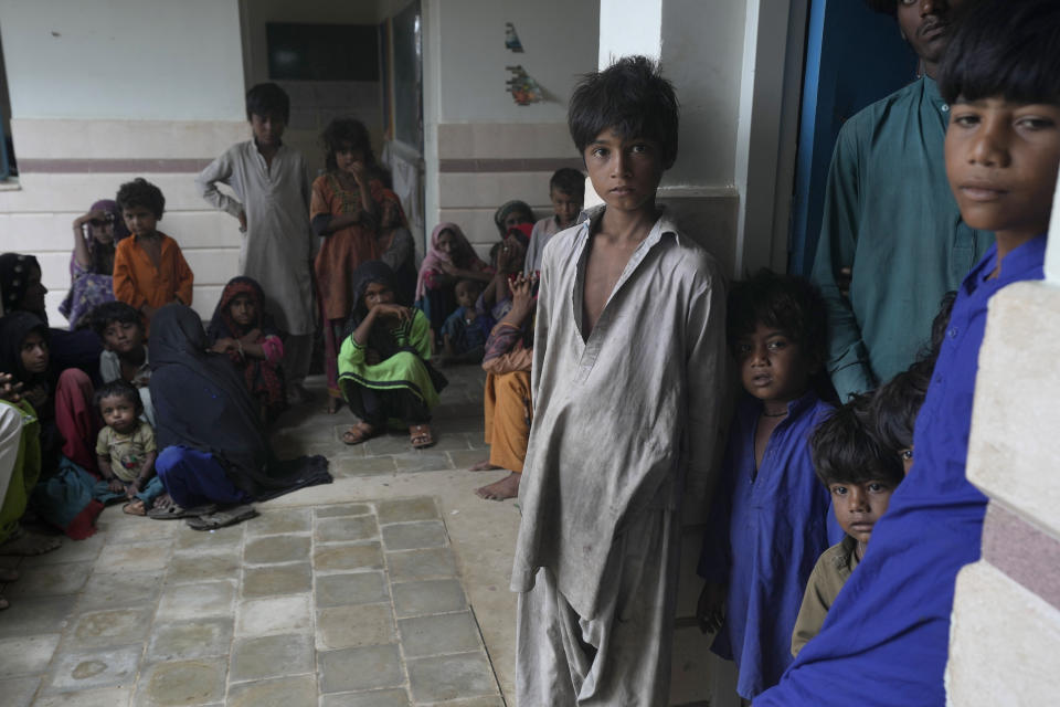 Women and children take shelter in a school after fleeing from their villages of costal areas due to Cyclone Biparjoy approaching, in Gharo near Thatta, a Pakistan's southern district in the Sindh province, Wednesday, June 14, 2023. In Pakistan, despite strong winds and rain, authorities said people from vulnerable areas have been moved to safer places in southern Pakistan's districts. With Cyclone Biparjoy expected to make landfall Thursday evening, coastal regions of India and Pakistan are on high alert. (AP Photo/Fareed Khan)