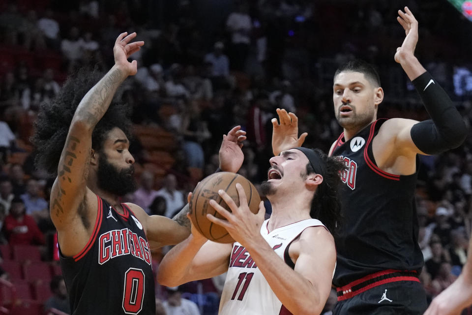 Miami Heat forward Jaime Jaquez Jr. (11) attempts a shot against Chicago Bulls guard Coby White (0) and center Nikola Vucevic during the first half of an NBA basketball play-in tournament game, Friday, April 19, 2024, in Miami. (AP Photo/Wilfredo Lee)