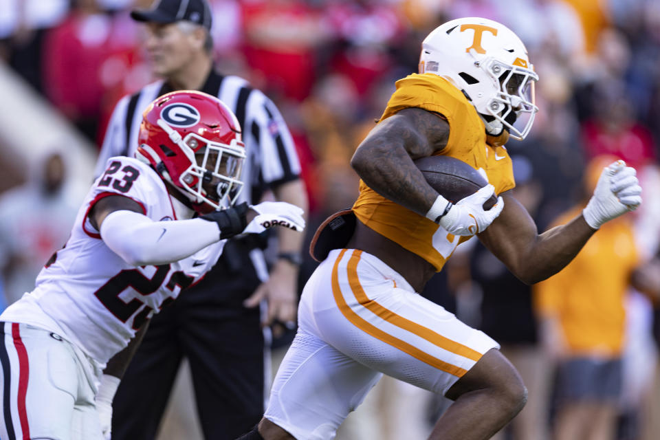 Tennessee running back Jaylen Wright (0) gets past Georgia defensive back Tykee Smith (23) enroute to a 75-yard touchdown during the first half of an NCAA college football game Saturday, Nov. 18, 2023, in Knoxville, Tenn. (AP Photo/Wade Payne)