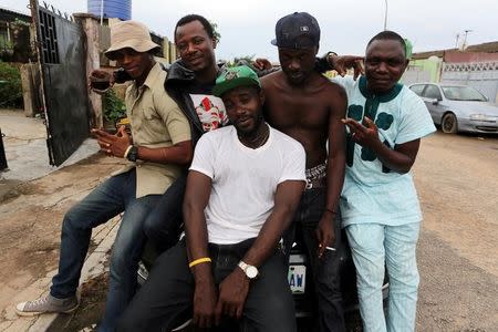 Members of the Fire Nation Blowing Purple Cloud hip hop crew pose for a picture outside recording studio in the Festac district of Lagos, Nigeria, May 17, 2016. REUTERS/Joe Penney