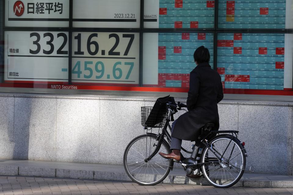 A person looks at an electronic stock board showing Japan's Nikkei 225 index at a securities firm Thursday, Dec. 21, 2023, in Tokyo. Asian shares fell Thursday after Wall Street hit the brakes on its big rally following disappointing corporate profit reports and warnings that the market had surged too far, too fast. (AP Photo/Eugene Hoshiko)