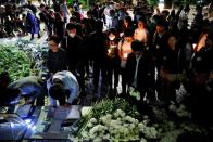 Students pay tribute with flowers to Chow Tsz-lok, 22, a university student who fell during protests at the weekend and died early on Friday morning, at the Hong Kong University of Science and Technology, in Hong Kong