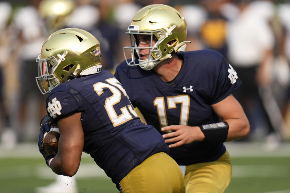 Notre Dame quarterback Jack Coan (17) hands off to running back Chris Tyree (25) in the second half of an NCAA college football game against Toledo in South Bend, Ind., Saturday, Sept. 11, 2021. Notre Dame won 32-29. (AP Photo/AJ Mast)