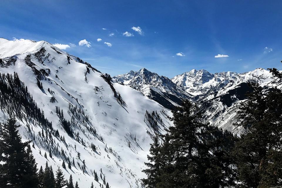 Skiers hike up the ridge line of 12,393 ft. Highland Peak above Highland Bowl far left on March 17, 2017 in Aspen, Colorado.