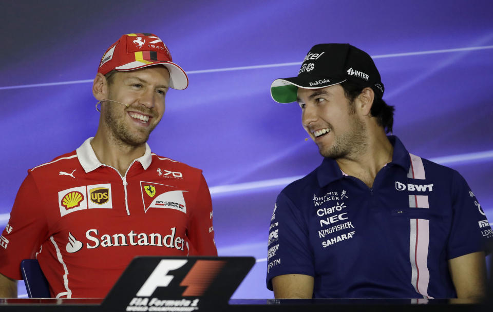 Ferrari driver Sebastian Vettel, left, of Germany smiles during a press conference with Force India driver Sergio Perez, of Mexico, ahead of Sunday's Formula One Italian Grand Prix, at the Monza racetrack, Italy, Thursday, Aug. 31, 2017. (AP Photo/Antonio Calanni)