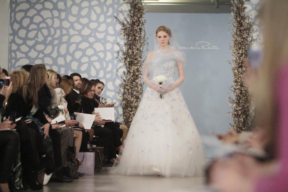 A model presents a bridal fashion creation from the Oscar de la Renta collection, in New York, Monday, April 22, 2013. (AP Photo/Bebeto Matthews)