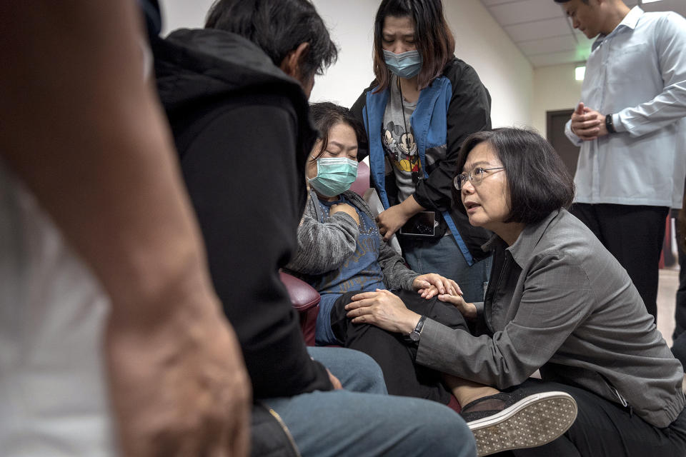 In this photo released by the Taiwan Presidential Office, Taiwanese President Tsai Ing-wen, center, consoles family members of victims from a train derailment at a hospital in Yilan county in northeastern Taiwan on Monday, Oct. 22, 2018. Passengers were killed and injured on Sunday when one of Taiwan's newer, faster trains derailed on a curve along a popular weekend route, officials said. (Taiwan Presidential Office via AP)