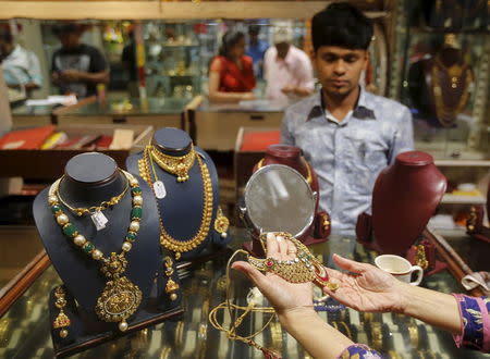 A customer tries a gold necklace at a jewellery showroom on the occasion of Dhanteras, a Hindu festival associated with Lakshmi, the goddess of wealth, at a market in Mumbai, India, November 9, 2015. REUTERS/Shailesh Andrade/Files