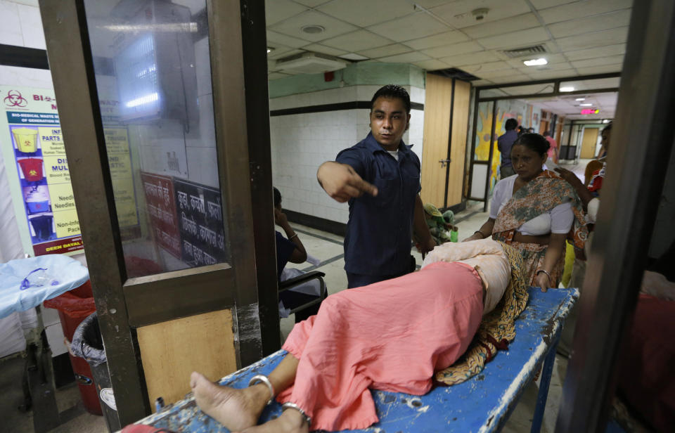 In this Tuesday, Aug. 21, 2012 photo, security guard Amarjeet Singh helps a patient on a stretcher at the Deen Dayal Upadhyay Hospital in New Delhi, India. Singh and 20 other bouncers have been hired to protect doctors as well as keep the emergency and labor rooms from filling up with patients’ often agitated relatives and friends. (AP Photo/Saurabh Das)